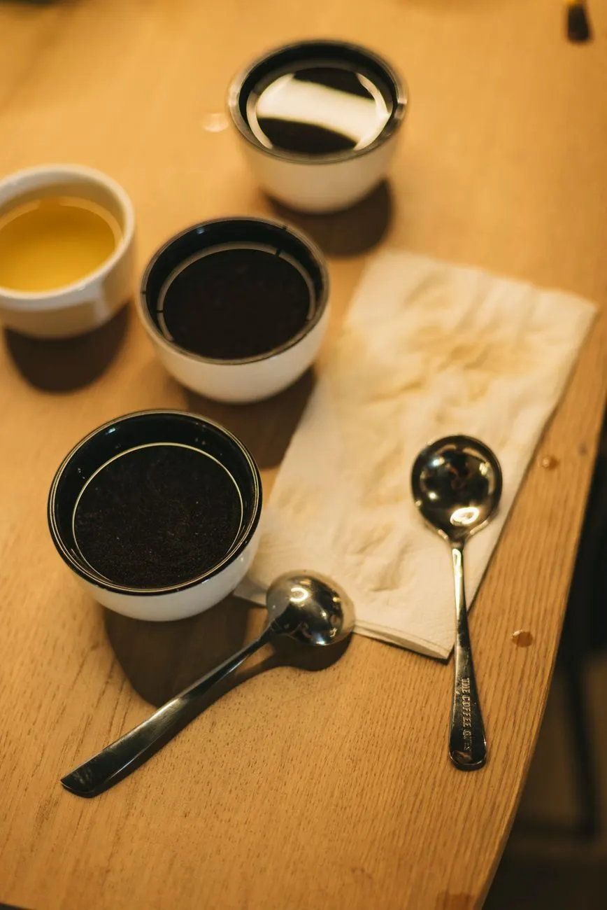 چیدمان چشیدن قهوه با فنجان و قاشق روی میز چوبی